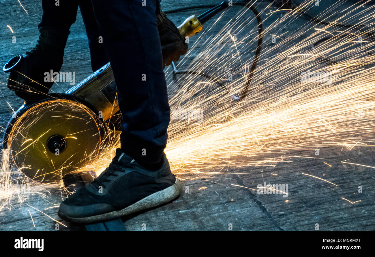 Mann schneidet Metall mit Winkelschleifer Stockfoto