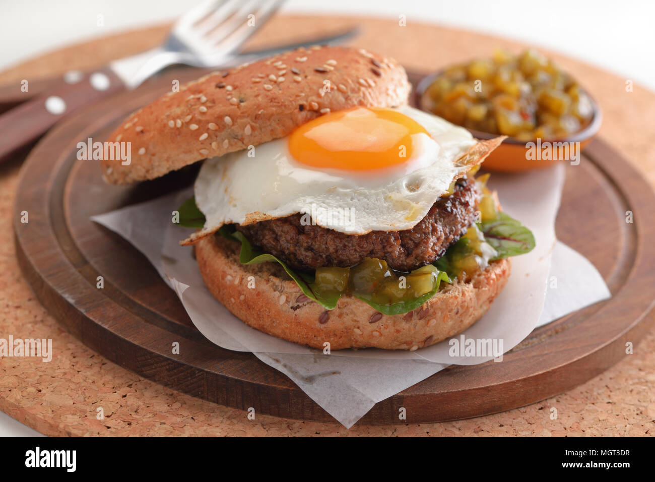 Hamburger mit Spiegelei und Gurke Salat Stockfoto