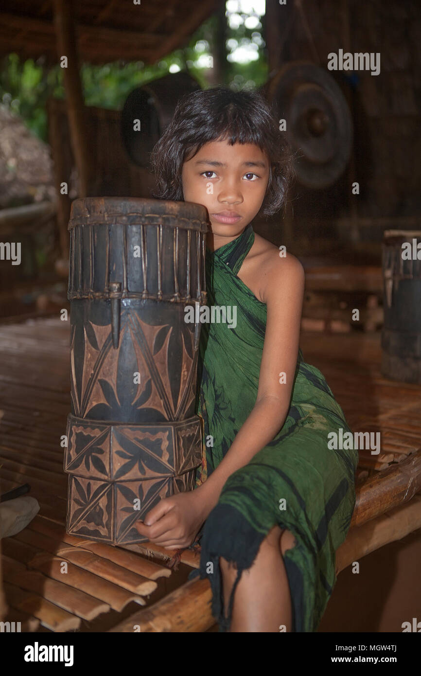 Portrait einer jungen Indigenen philippinischen Mädchen aus dem Palaw" einen Stamm mit einem Dabakan, Philippinische geschnitzten drum, im Eco Schmetterlingsgarten und Tri genommen Stockfoto