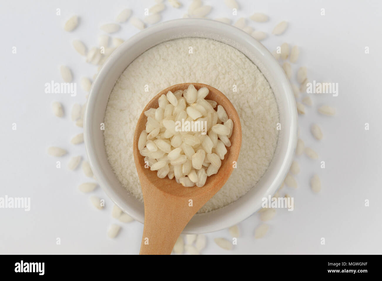 Weißer Reis Körner auf Holzlöffel und Reis Mehl in Schüssel Stockfoto