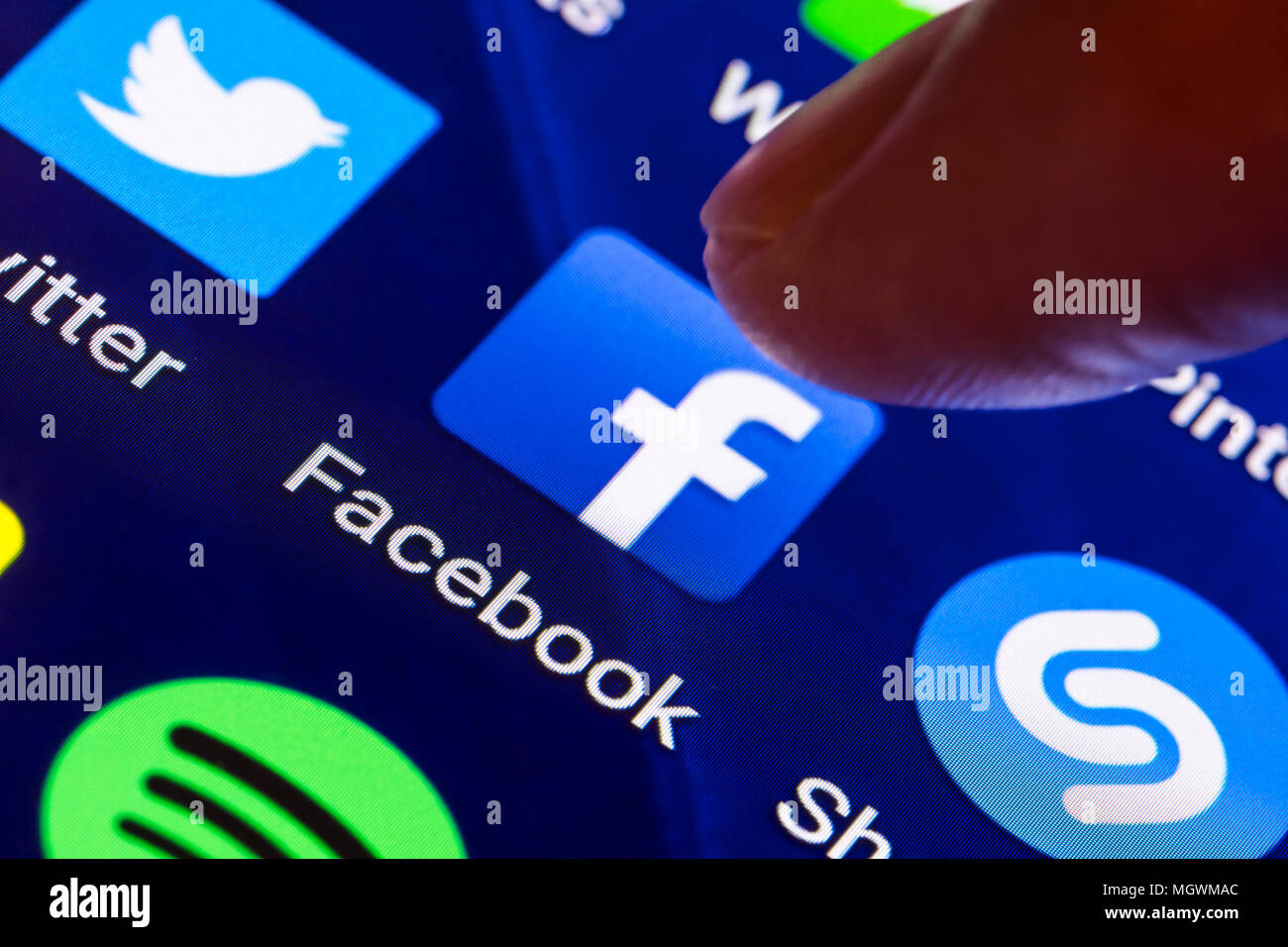 Facebook Symbol. Finger, mit dem ein Symbol der Facebook App auf einem Tablet-PC oder Bildschirm des Smartphones zu laden. Taste "Facebook". Stockfoto