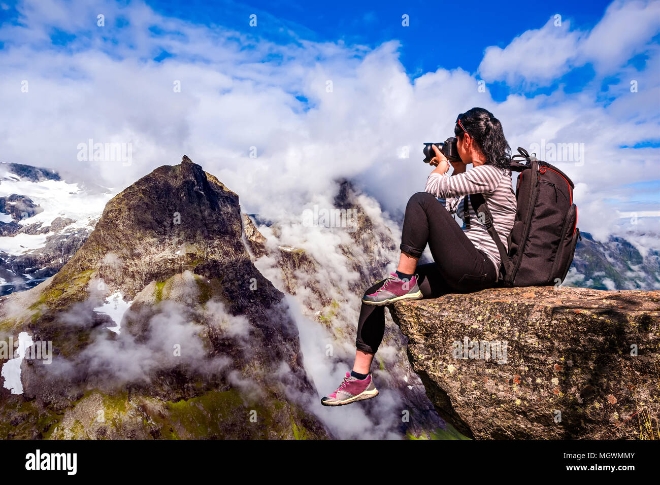 Natur-Fotograf-Tourist mit Kamera schießt beim stehen oben auf dem Berg. Wunderschöne Natur Norwegens. Stockfoto