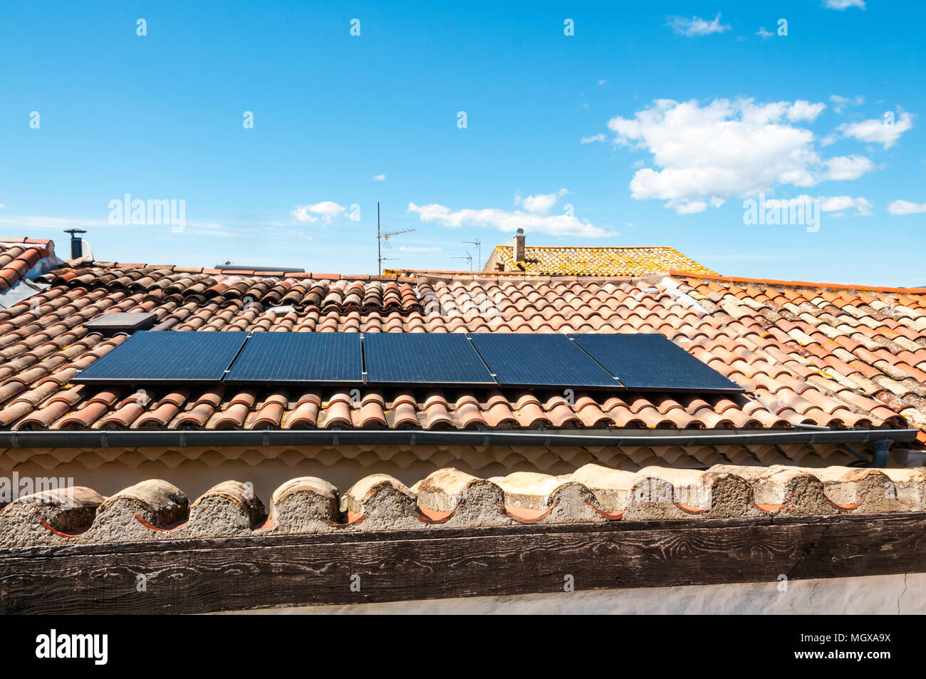 Sonnenkollektoren auf Fliesen- Dach eines Hauses in einem kleinen Dorf des Languedoc in Südfrankreich. Stockfoto