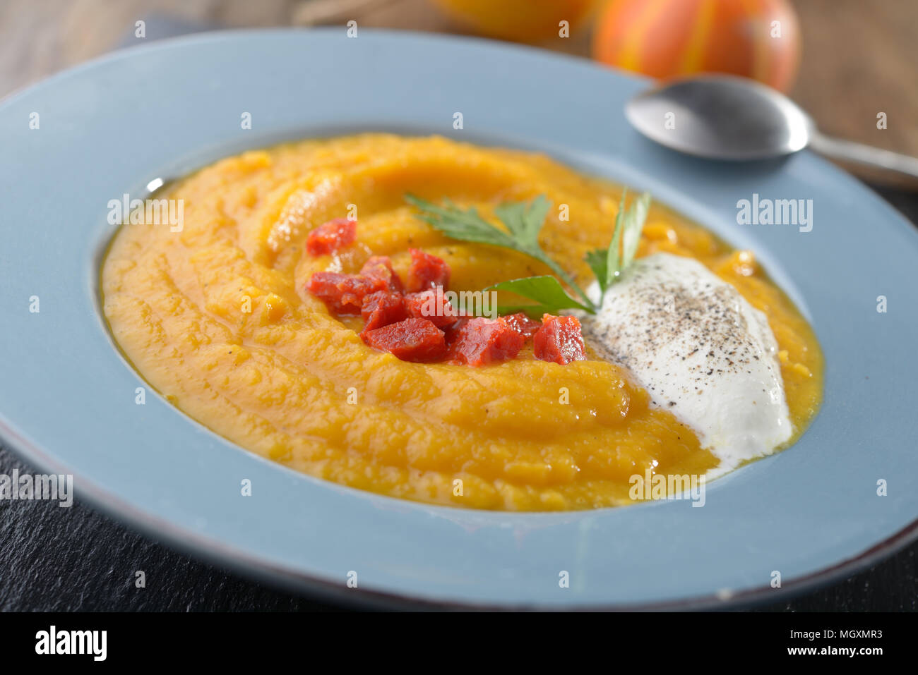 Kürbissuppe mit Chorizo, saure Sahne und Petersilie Stockfoto