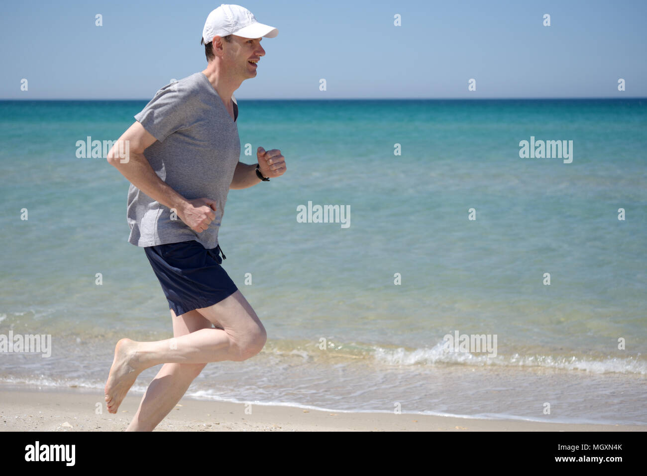 Man barfuß Joggen am Strand Stockfoto