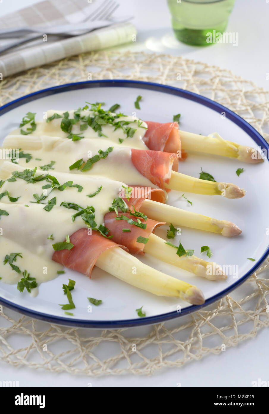 Weißer Spargel rolled-up in jamon unter Käse Sauce Stockfoto