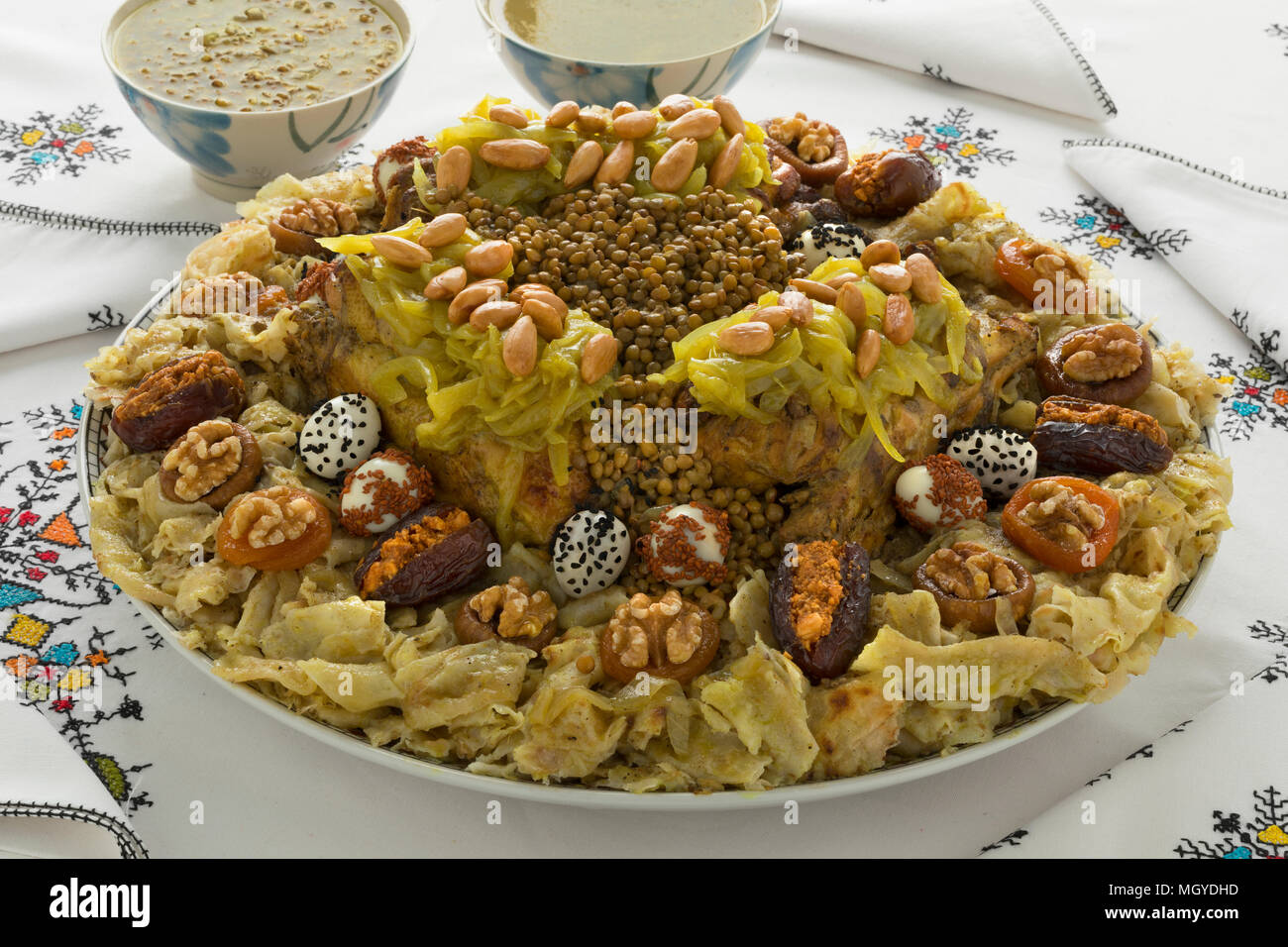 Festliche traditionelle marokkanische Rfissa, serviert mit Sauce und decorared mit Wachteleier, Samen, Früchte und Nüsse Stockfoto