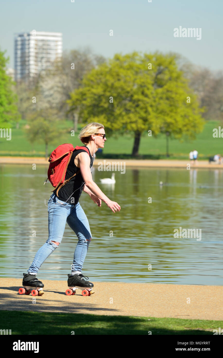 Junge Frau Roller Skating Neben der Serpentine, Hyde Park, London, Vereinigtes Königreich Stockfoto