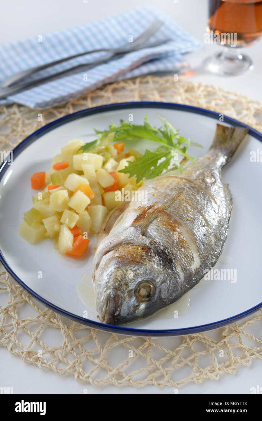 Gebackene Dorade mit Kartoffeln, Karotten und Sellerie Stockfoto