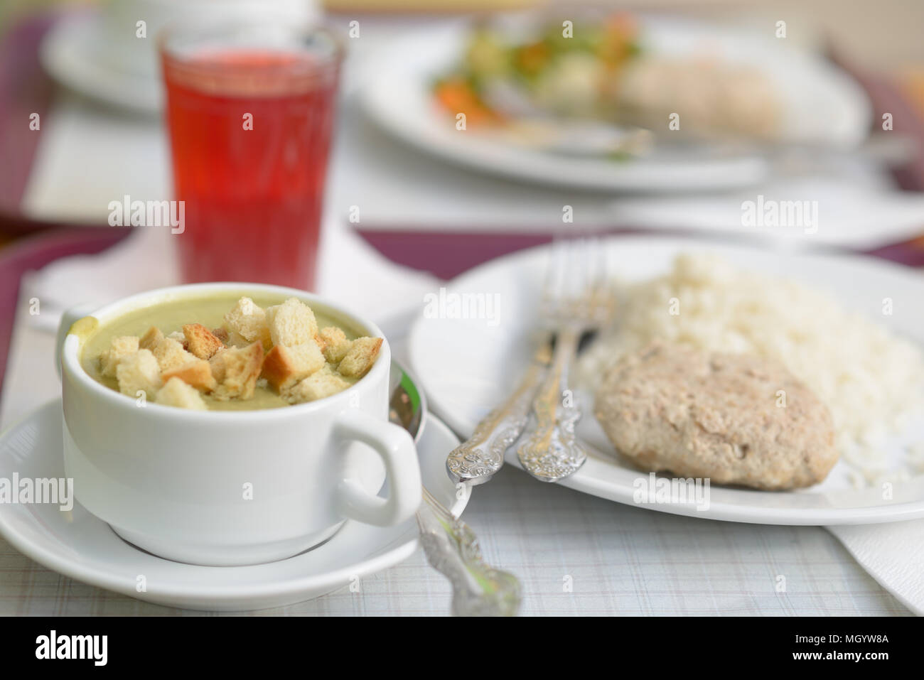 Abendessen mit Creme von Brokkoli Suppe, Frikadelle und Reis Stockfoto