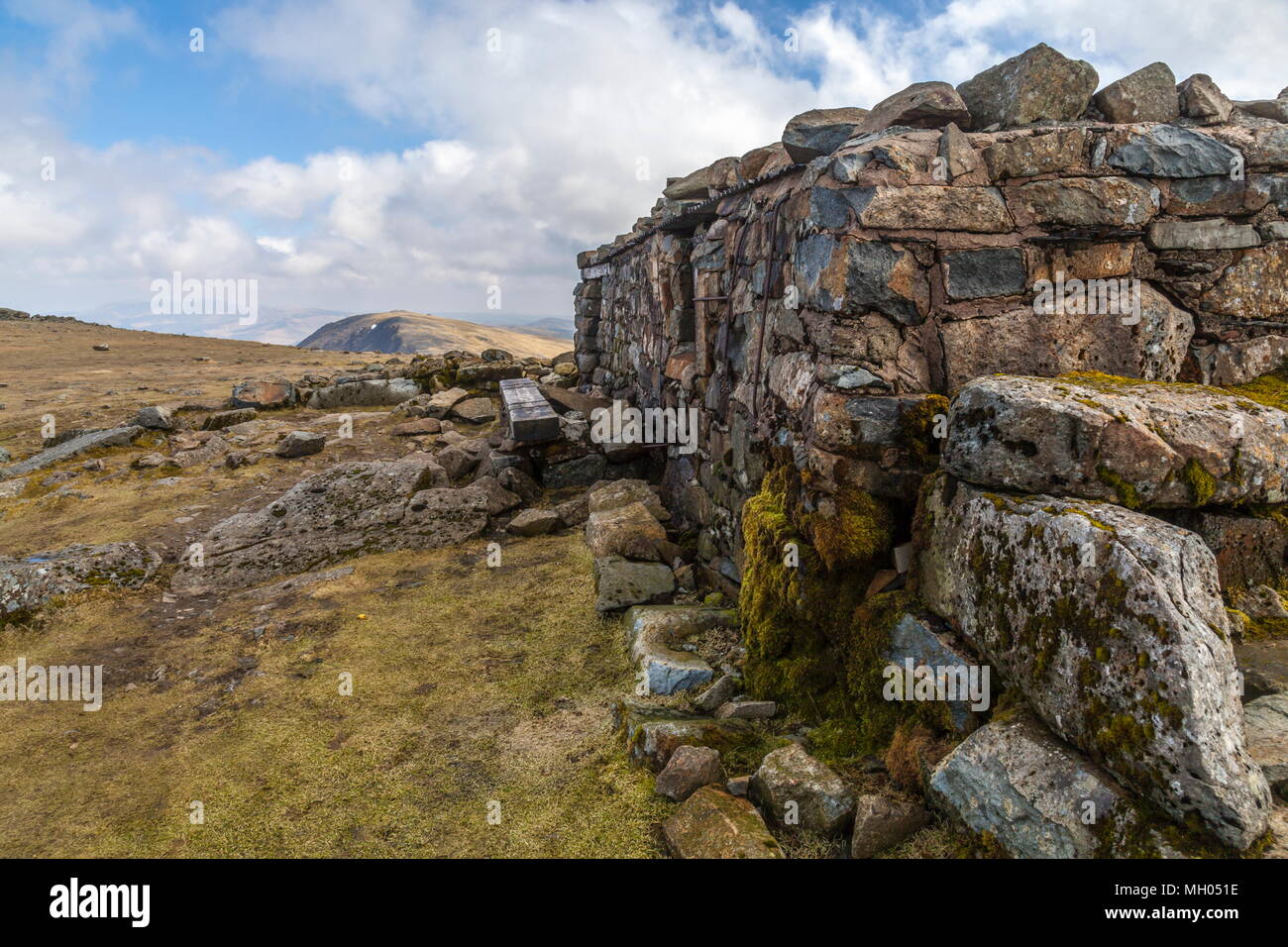 Die viel Willkommen im Tierheim auf dem Gipfel des Cadair Idris mit Mynydd Moel im Hintergrund. Stockfoto