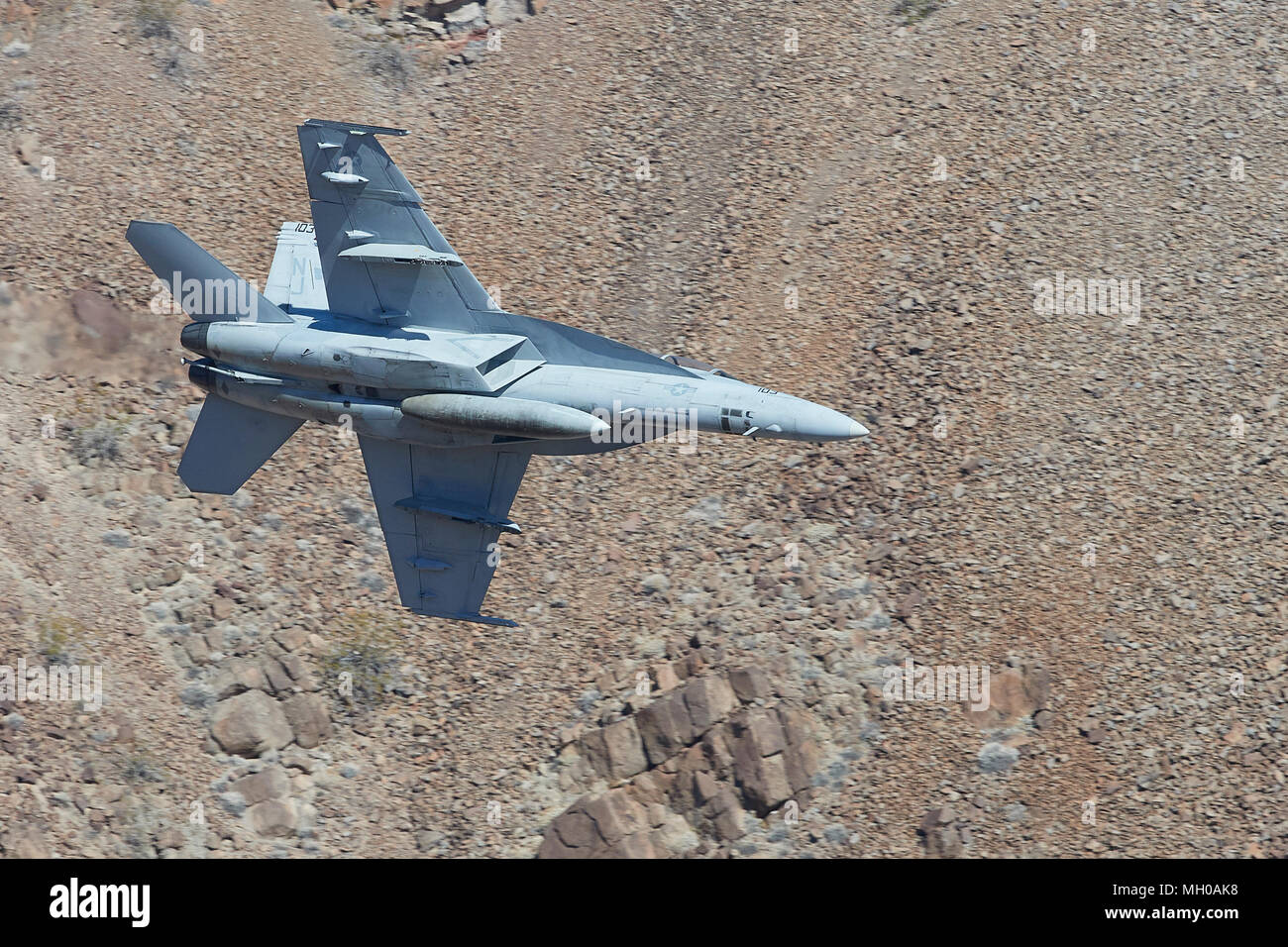 Profil anzeigen von United States Navy F/A-18F Super Hornet Jet Fighter Banking und Flying Low durch Rainbow Canyon, Kalifornien, USA. Stockfoto