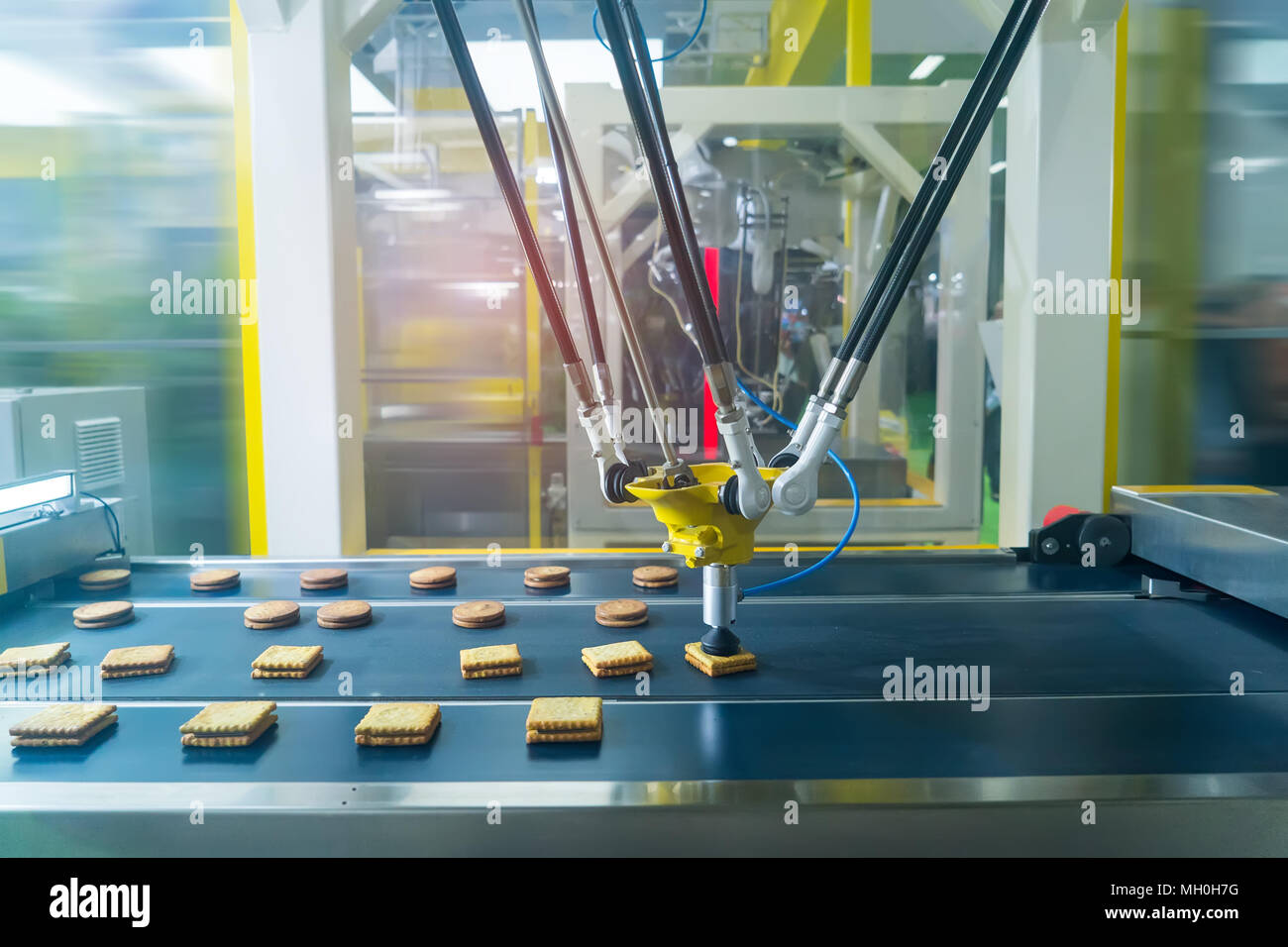 Roboter mit Vakuumsauger mit Transportband in der Produktion von Cookies in  einem fertigen Werk für die Lebensmittelindustrie Stockfotografie - Alamy