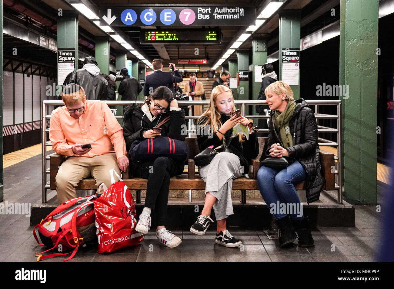 Eine Gruppe der Pendler auf einer Bank in der New Yorker U-Bahn. Aus einer Reihe von Fotos in den Vereinigten Staaten. Foto Datum: Donnerstag, 5. April 2018. Stockfoto