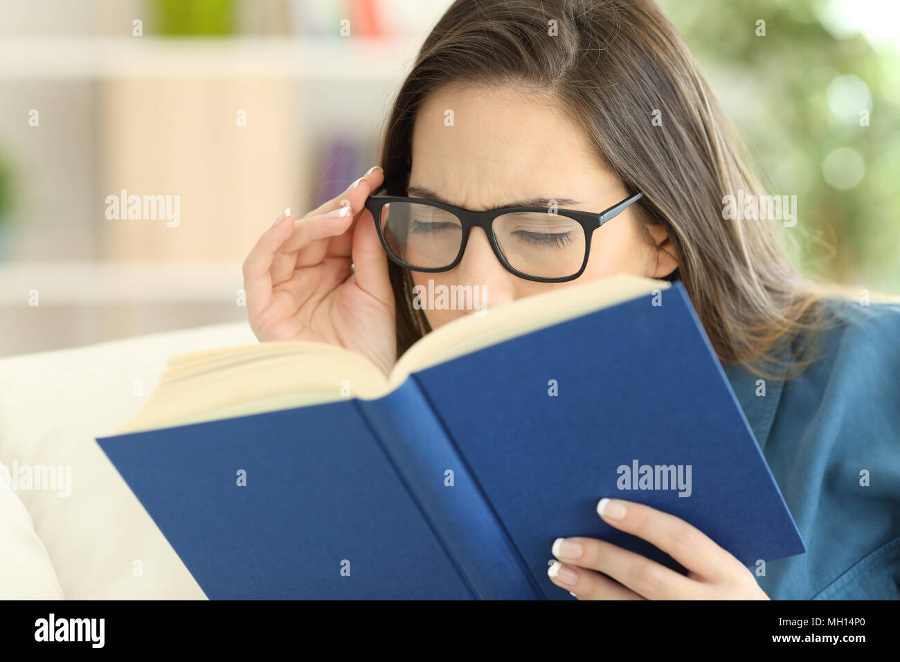 Frau Mit Einer Uberanstrengung Der Augen Ein Buch Lesen Brille Zu Hause Tragen Stockfotografie Alamy