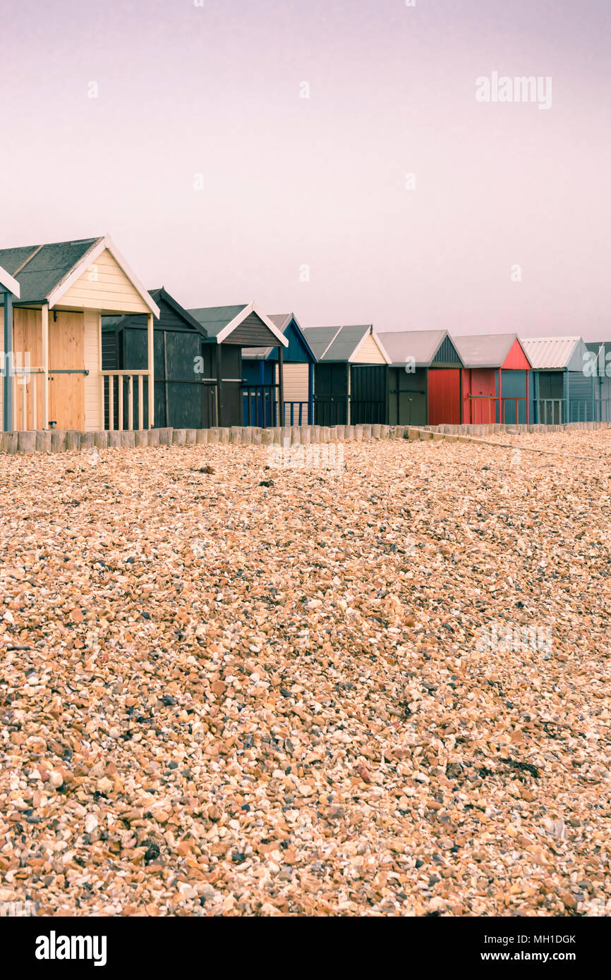 Bunte split getönten Umkleidekabinen am Strand entlang Calshot Spit an einem bewölkten bewölkt Tag, Calshot, England, Großbritannien Stockfoto