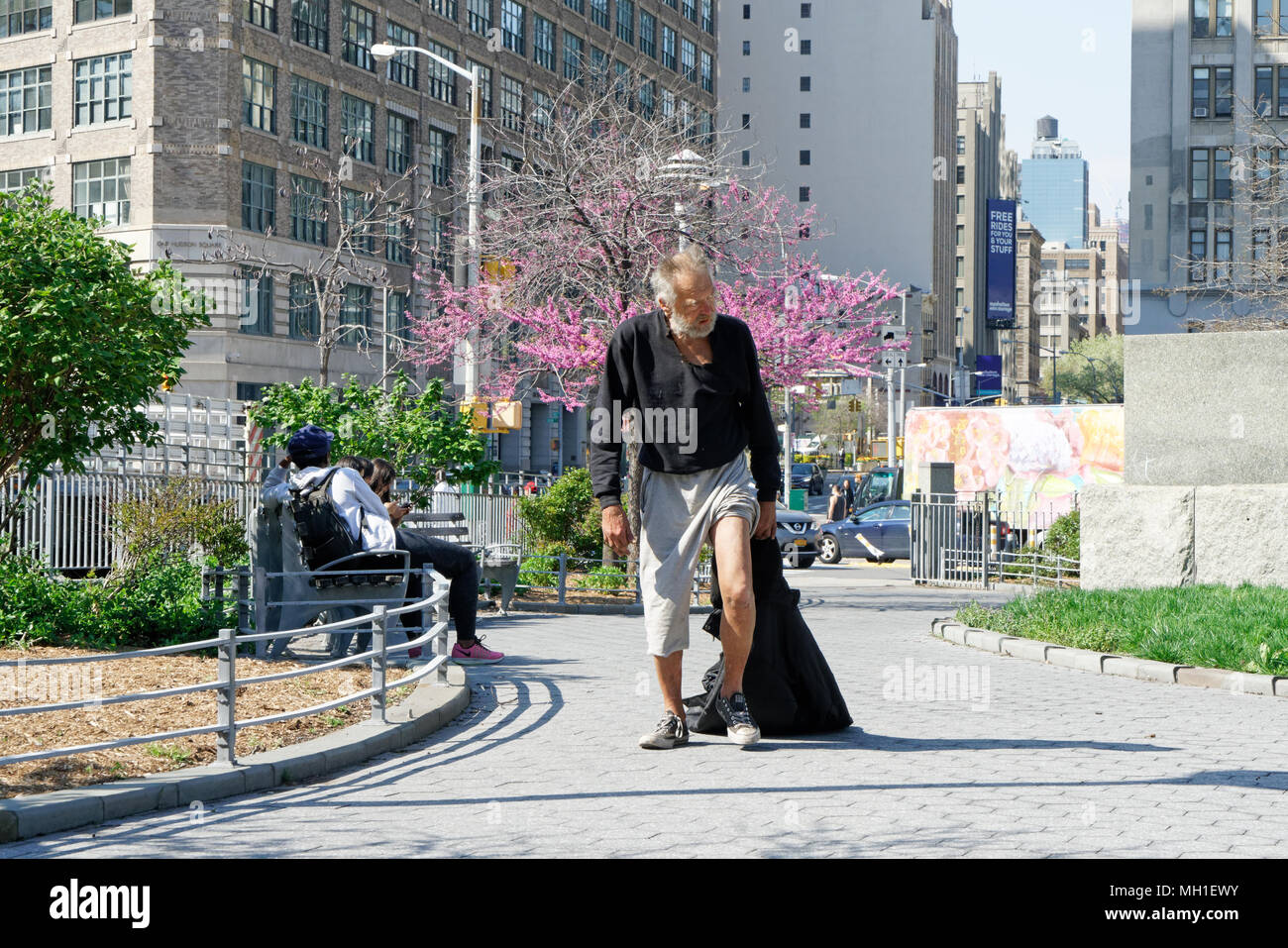 Ein obdachloser Mann Sammeln von Flaschen für Recycling ging durch Capsouto Park in Tribeca an einem sonnigen Tag im Frühling. Stockfoto