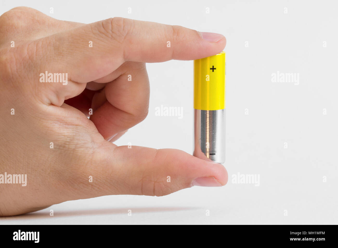 Finger holding AA-Alkali-Mangan Batterie Stockfoto