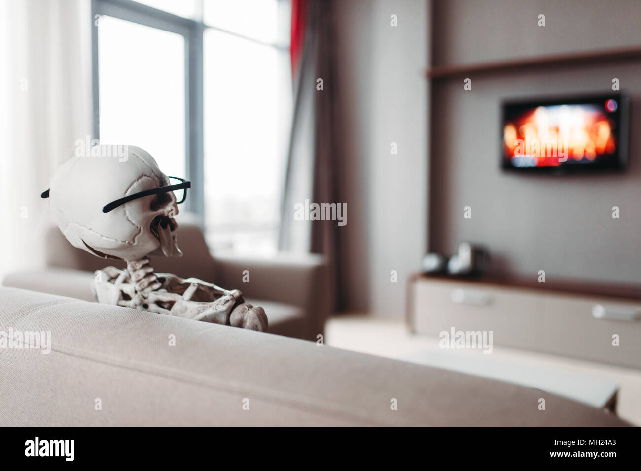 Skelett in Gläsern sitzen auf der Couch und Fernsehen. Stockfoto