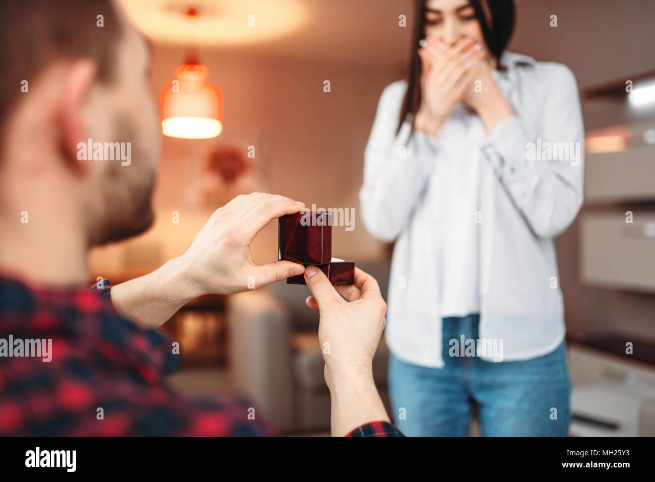 Junger Mann macht ein Angebot überrascht Frau Stockfoto