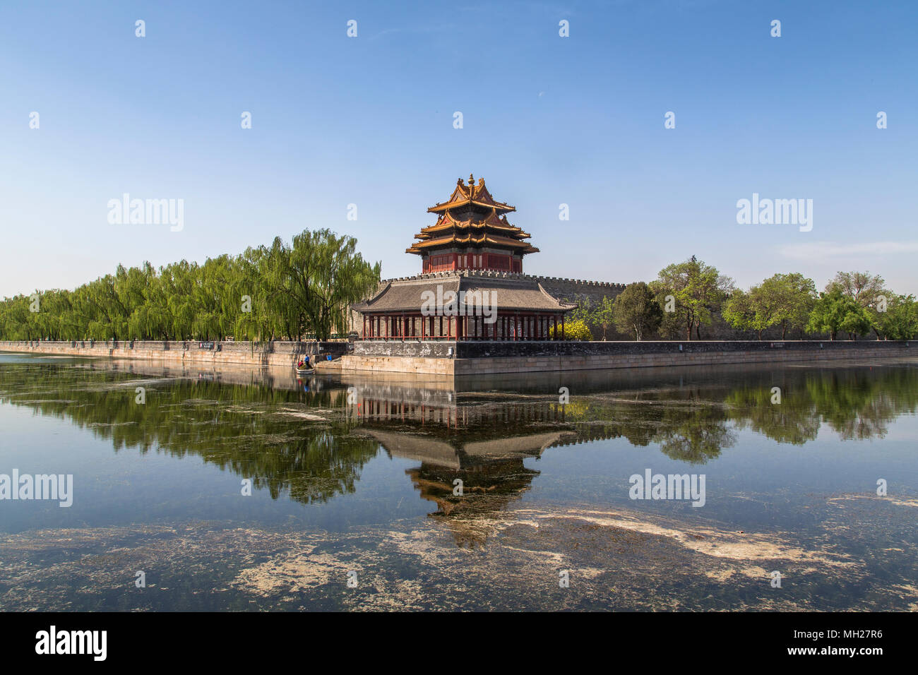 Nordostecke Turm der Verbotenen Stadt in Peking, China. Zwei Männer in einem kleinen Boot auf dem Graben, dass die Stadtmauer umgibt gesehen werden. Stockfoto