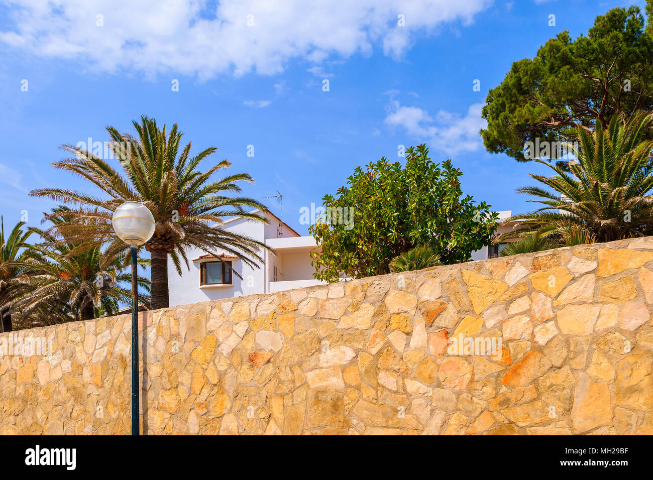 Typische spanische Villa in tropischen Garten - Blick von der Uferpromenade von Cala Gat Strand, Insel Mallorca, Spanien Stockfoto