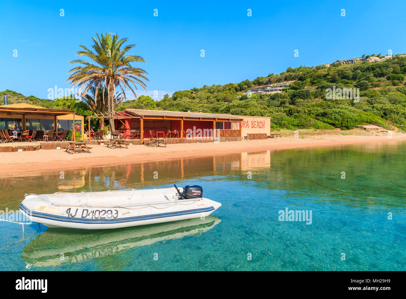 Korsika, Frankreich - 23.Juni, 2015: Beiboot boot Verankerung in der kleinen Bucht mit Strand und Restaurant auf sonnigen Sommertag. Diese französische Insel ist beliebt Stockfoto