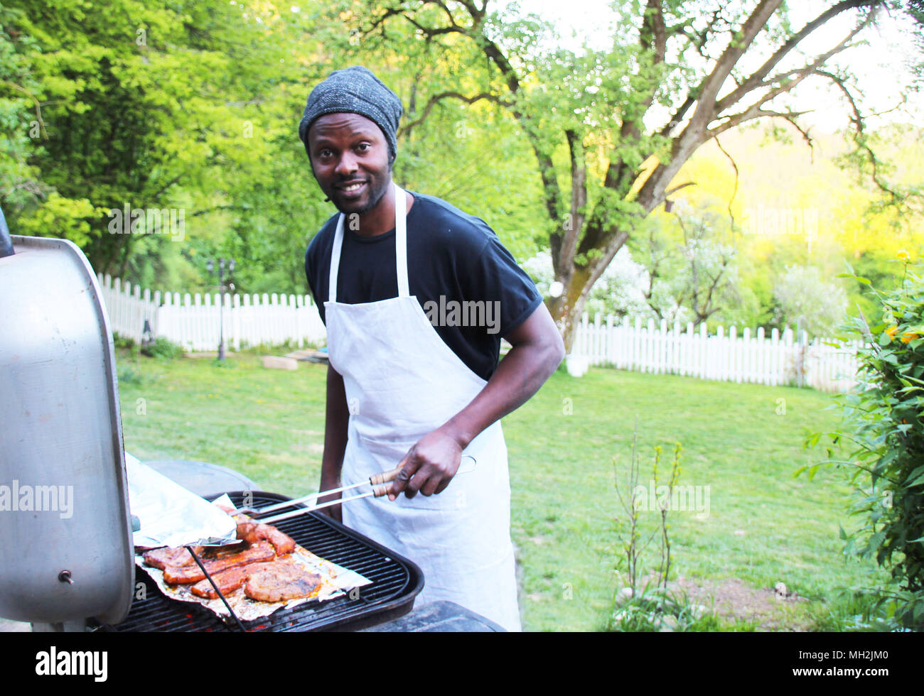 Ein fröhlicher Mann Grills im Freien im Park Stockfoto