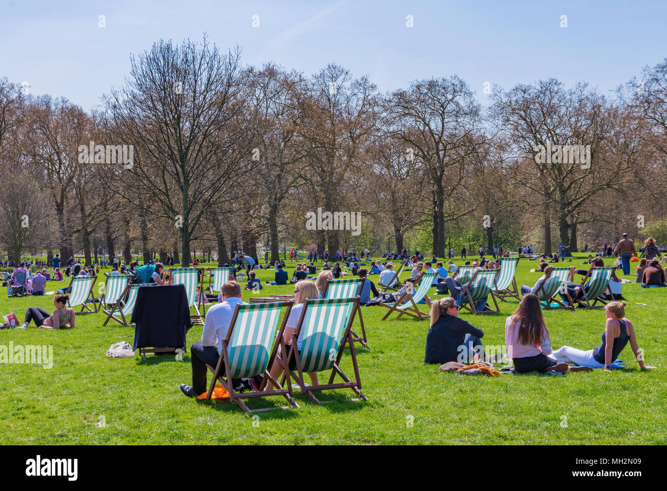 LONDON, Großbritannien - 18 April: Menschen Sonnenbaden und Relaxen an einem heißen sonnigen Tag im Green Park am 18. April 2018 in London. Stockfoto