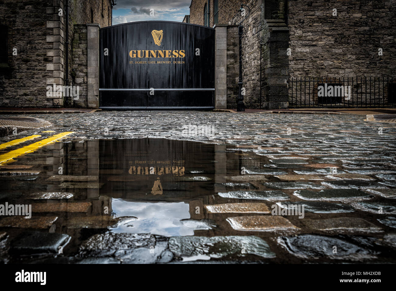 Alte Tor von Guinness St. James Gate Brauerei mit Reflexion in der Pfütze. Stockfoto