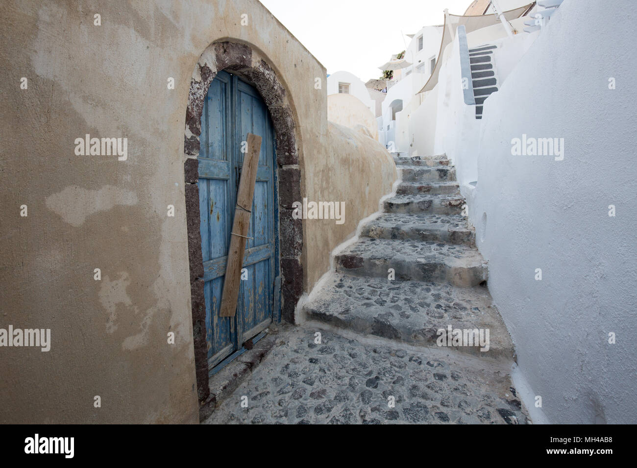 Schmale Straße mit Kopfsteinpflaster mit Treppe in Santorini Stockfoto