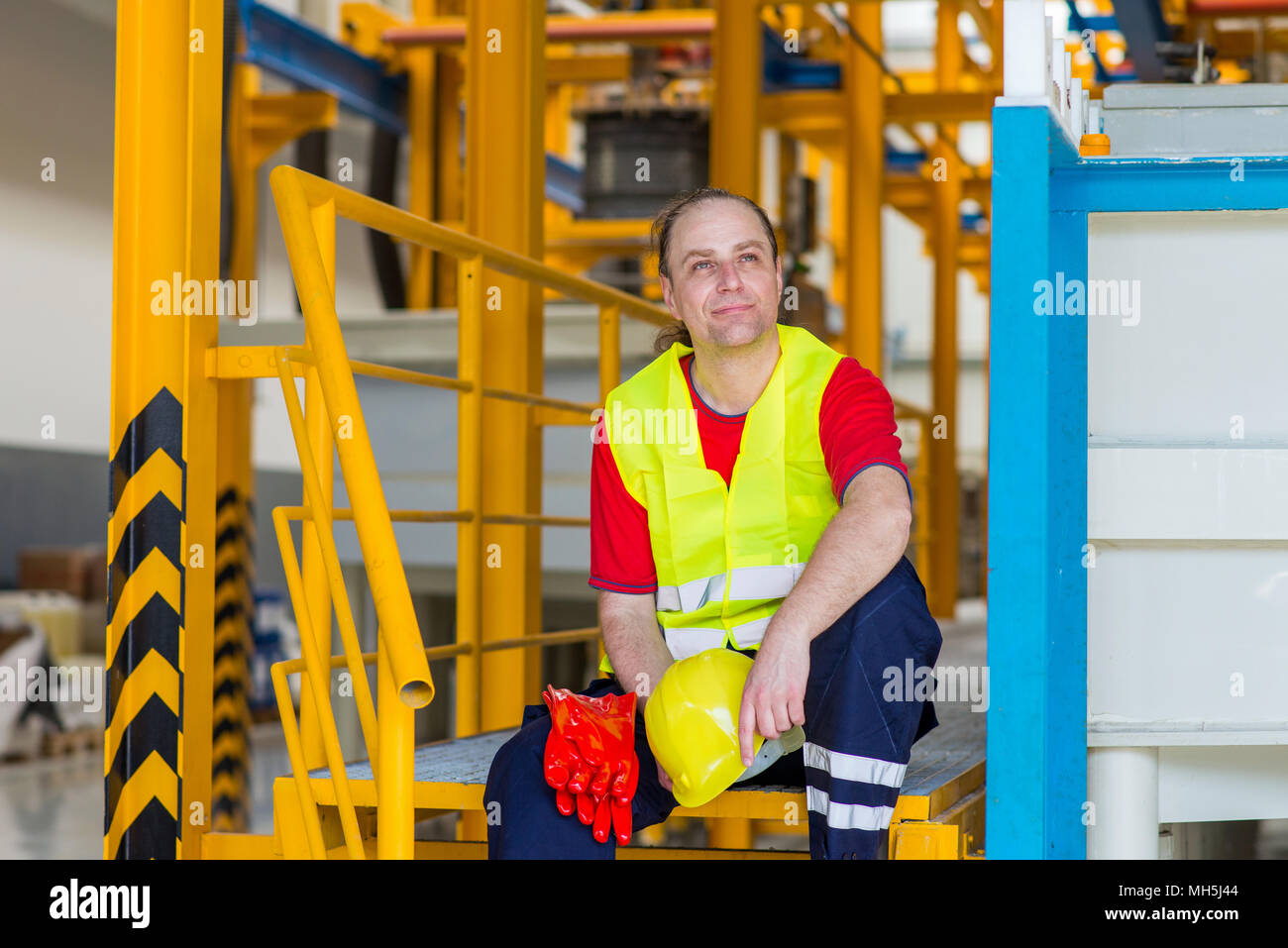 Arbeiter in einer Fabrik Sitzen und Ruhen während einer Arbeit Stockfoto
