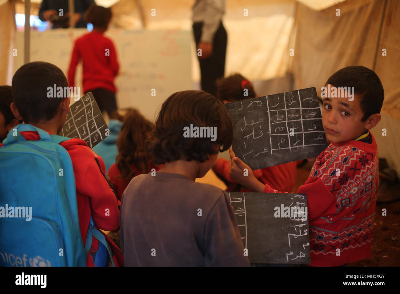 Idlib, Syrien. 30 Apr, 2018. Syrische Kinder Arabisch lernen in einer Klasse an einem provisorischen Schule von einem Flüchtlingslager in Idlib, Syrien, 30. April 2018. Die Schule umfasst rund 300 Schüler verschiedener Altersgruppen. Credit: Anas ALkharboutli/dpa/Alamy leben Nachrichten Stockfoto