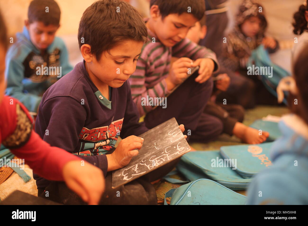 Idlib, Syrien. 30 Apr, 2018. Syrische Kinder Arabisch lernen in einer Klasse an einem provisorischen Schule von einem Flüchtlingslager in Idlib, Syrien, 30. April 2018. Die Schule umfasst rund 300 Schüler verschiedener Altersgruppen. Credit: Anas ALkharboutli/dpa/Alamy leben Nachrichten Stockfoto