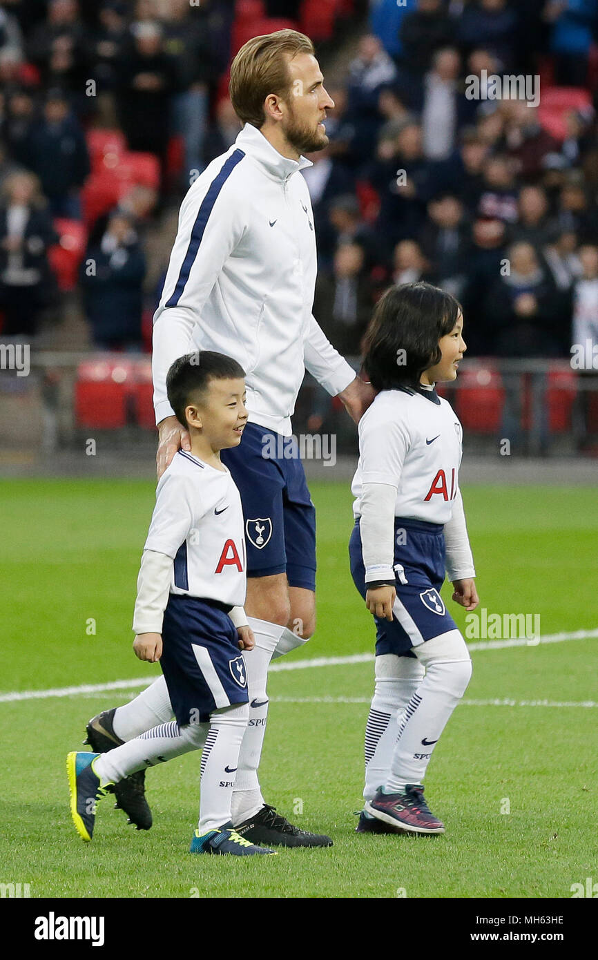London, Großbritannien. 30 Apr, 2018. Tottenham Hotspur ist Harry Kane geht in die Tonhöhe mit ballkids aus China vor dem Premier League Fußball Match zwischen den Tottenham Hotspur und Watford im Wembley Stadion in London, Großbritannien, 30. April 2018. Tottenham Hotspur gewann 2-0. Quelle: Tim Irland/Xinhua/Alamy leben Nachrichten Stockfoto
