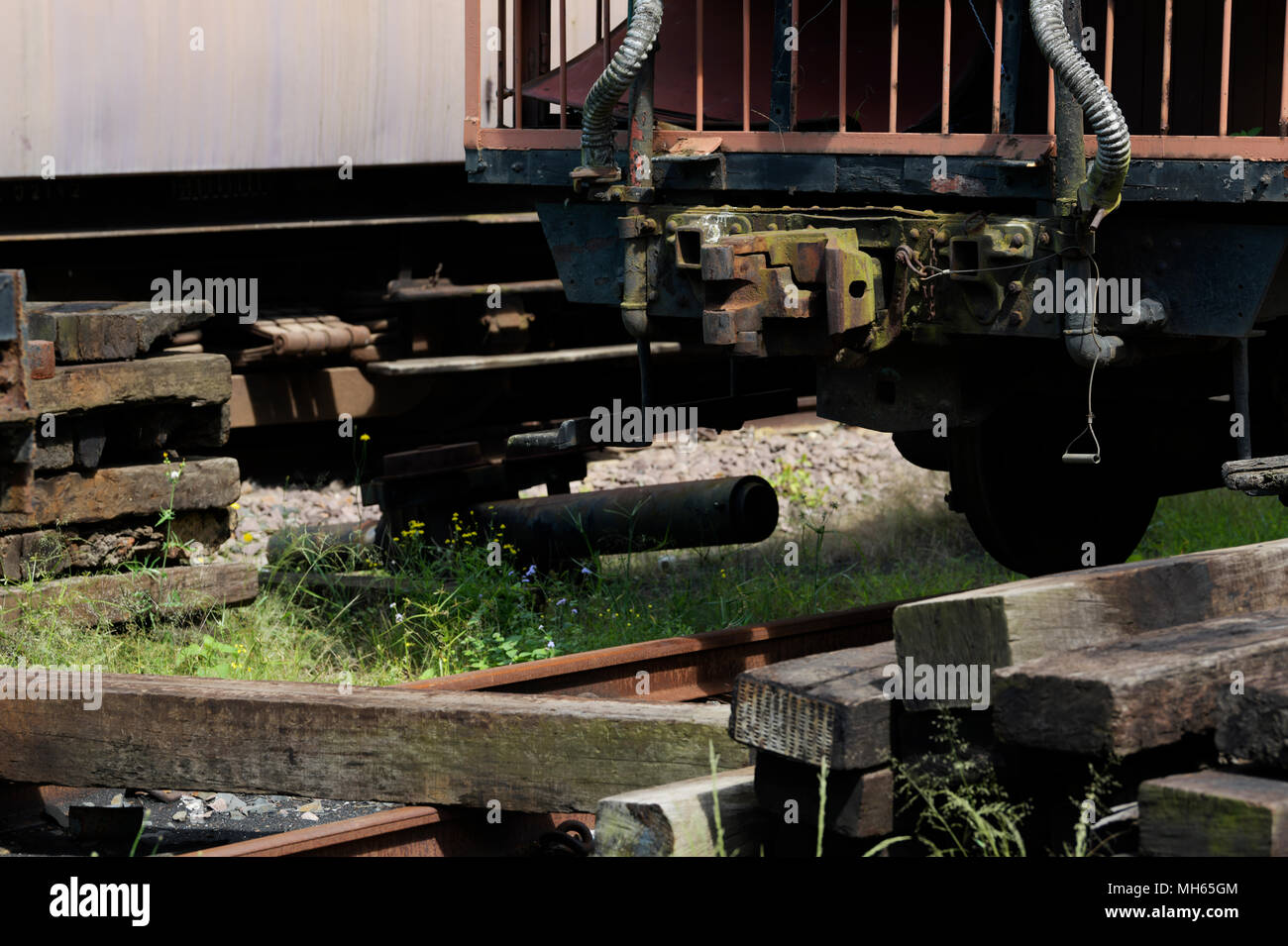 Verworfen, Haufen von Bahnschwellen liegen neben der Kopplung von einem verlassenen Schienenbus. Stockfoto