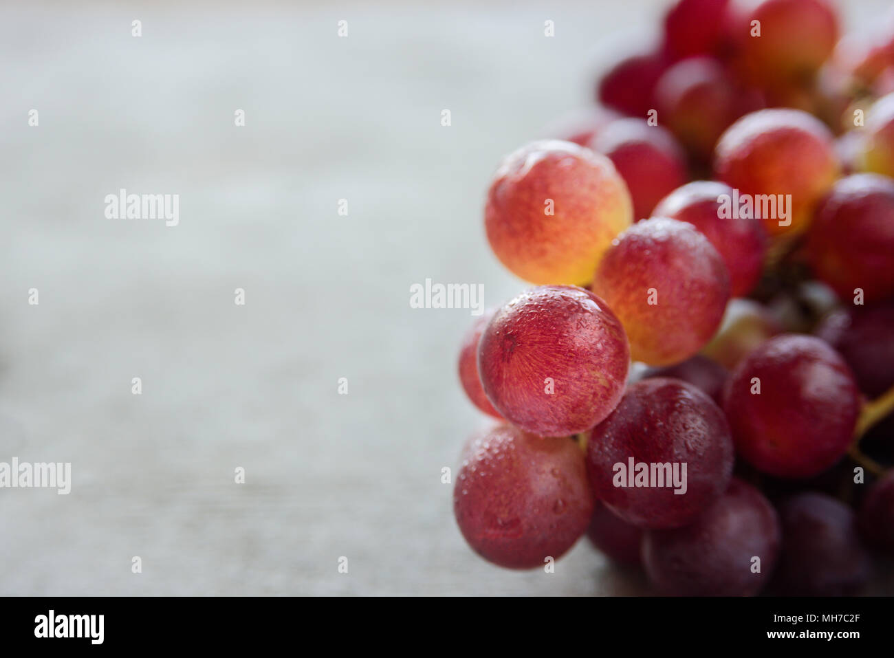 Frische saftige Strauß roter Trauben fuit auf hölzernen Hintergrund Stockfoto