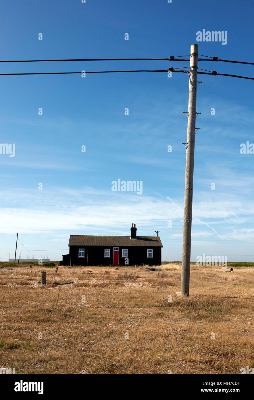 Ein einsames Haus in Dungeness mit einem telegraphenmast in Kent, England, Großbritannien Stockfoto