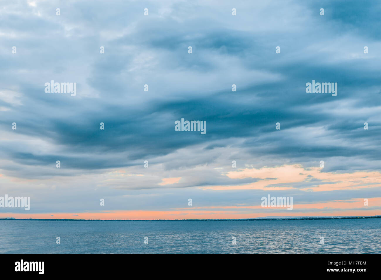 Seascape - bewölkten Himmel über ruhige Bucht Gewässer bei Sonnenuntergang Stockfoto