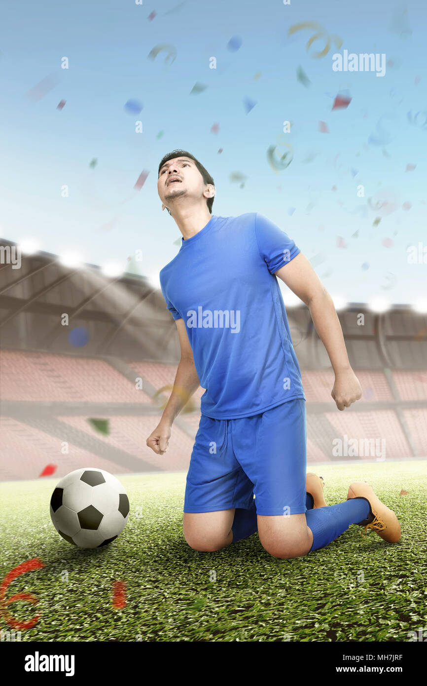 Junge asiatische Fußball-Spieler feiern den Sieg auf dem Feld Stockfoto