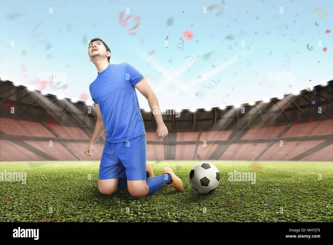 Glück asiatischen Fußball-Spieler mit aufgeregten Ausdruck auf dem Feld Stockfoto