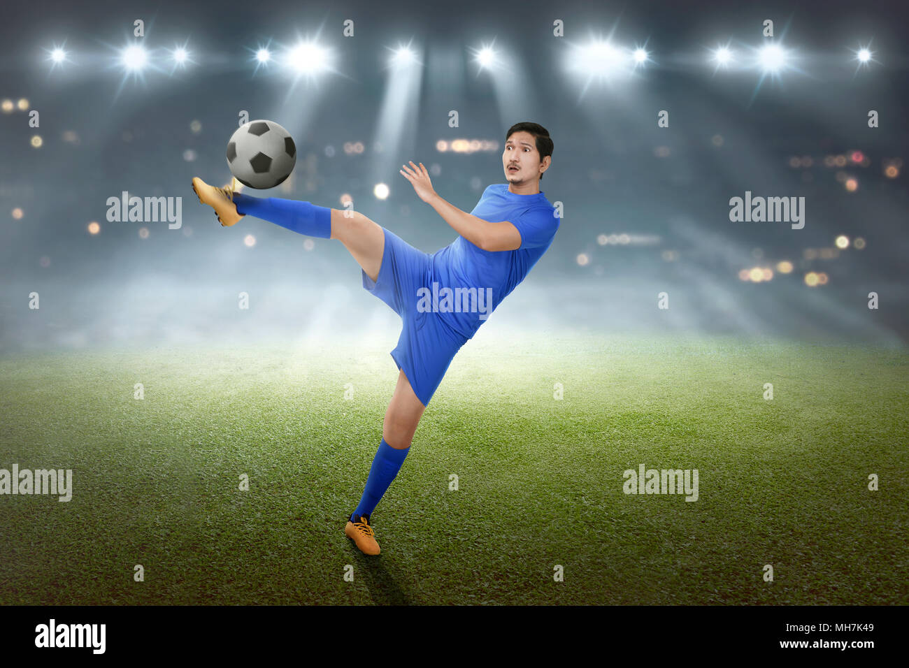 Asiatische Fußballspieler seine Fähigkeiten zeigen Bei match Aufgeregt Stockfoto