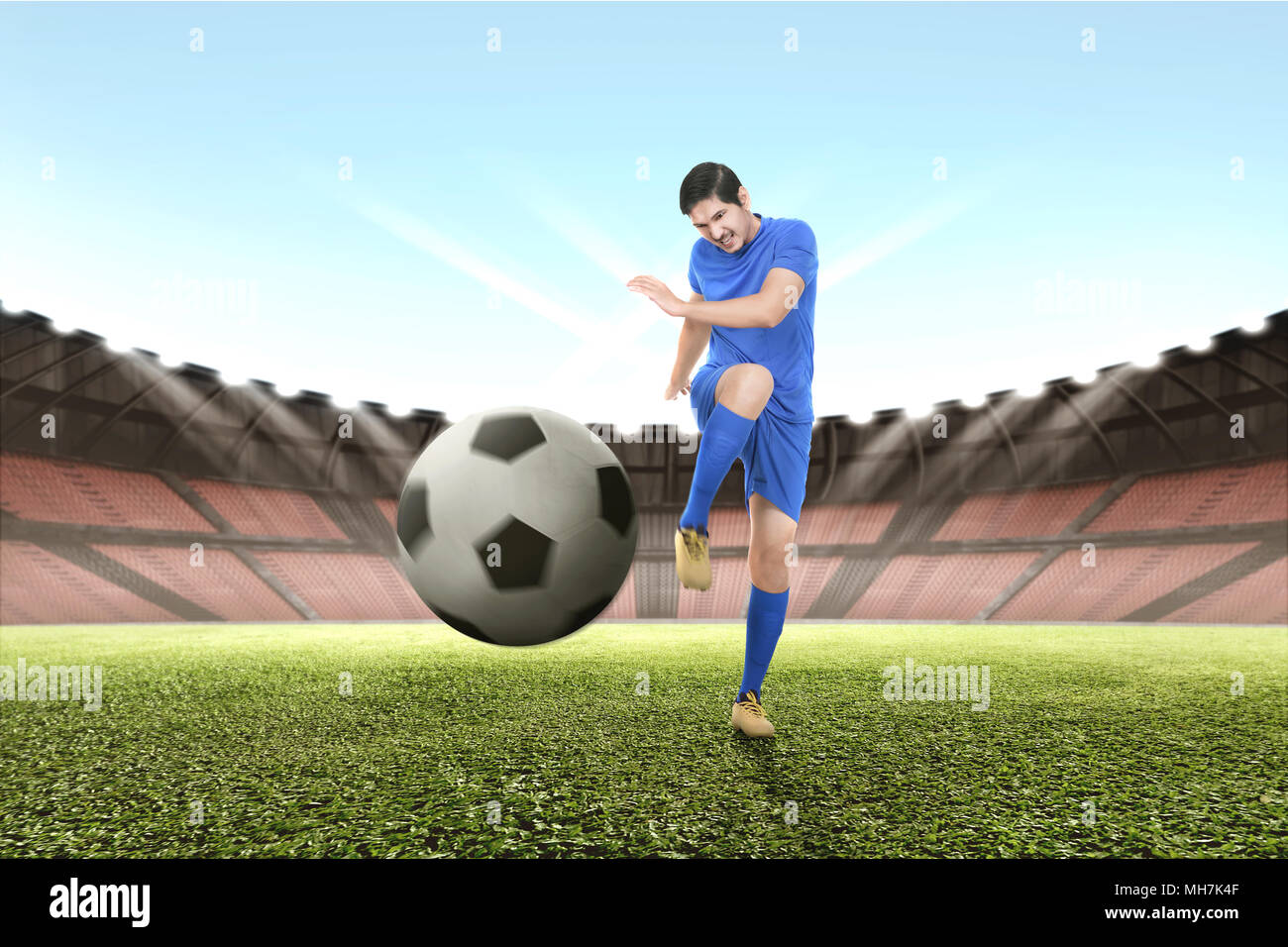 Schönen asiatischen Fußball-Spieler üben mit der Kugel am Stadion Stockfoto