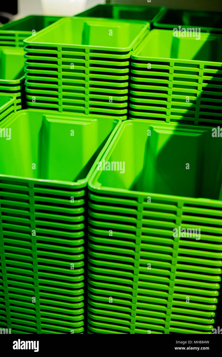 Ein Stapel von grünen Plastikeimer. Selektive konzentrieren. Kunststoffbehälter. Shopping Mall. Bild vertikal Stockfoto