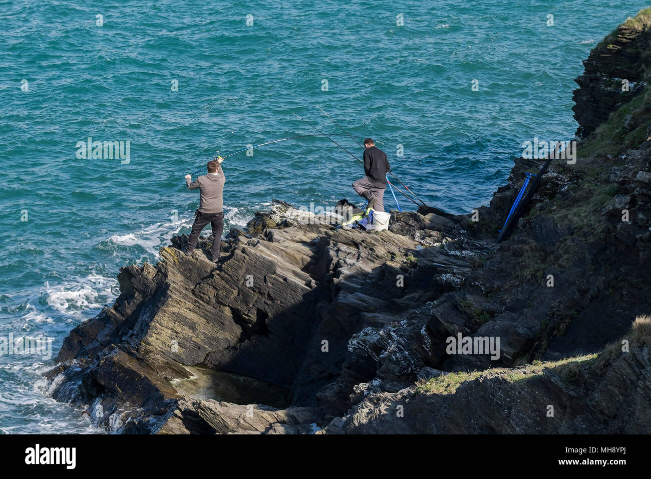 Angler Angeln aus Felsen in Newquay in Cornwall. Stockfoto