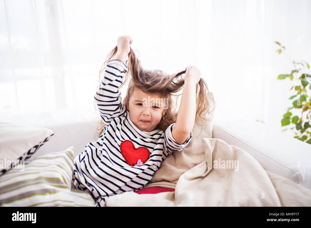 Eine kleine glückliche Mädchen in gestreiften T-Shirt zu Hause Spaß. Stockfoto