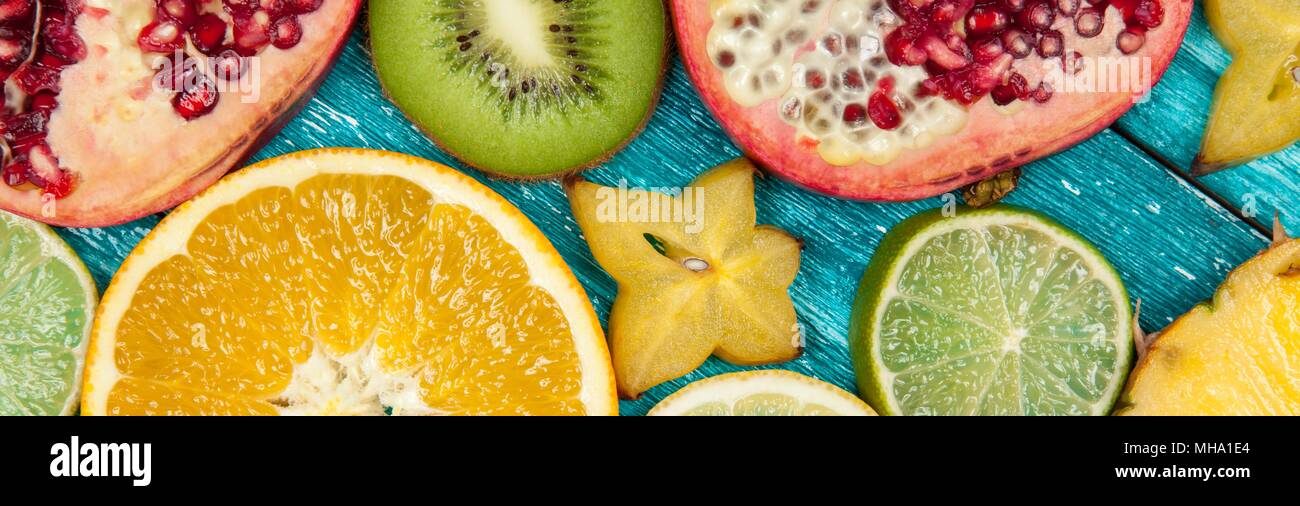 Bunte FRUCHTSCHEIBEN auf blauen Holzoberfläche Stockfoto