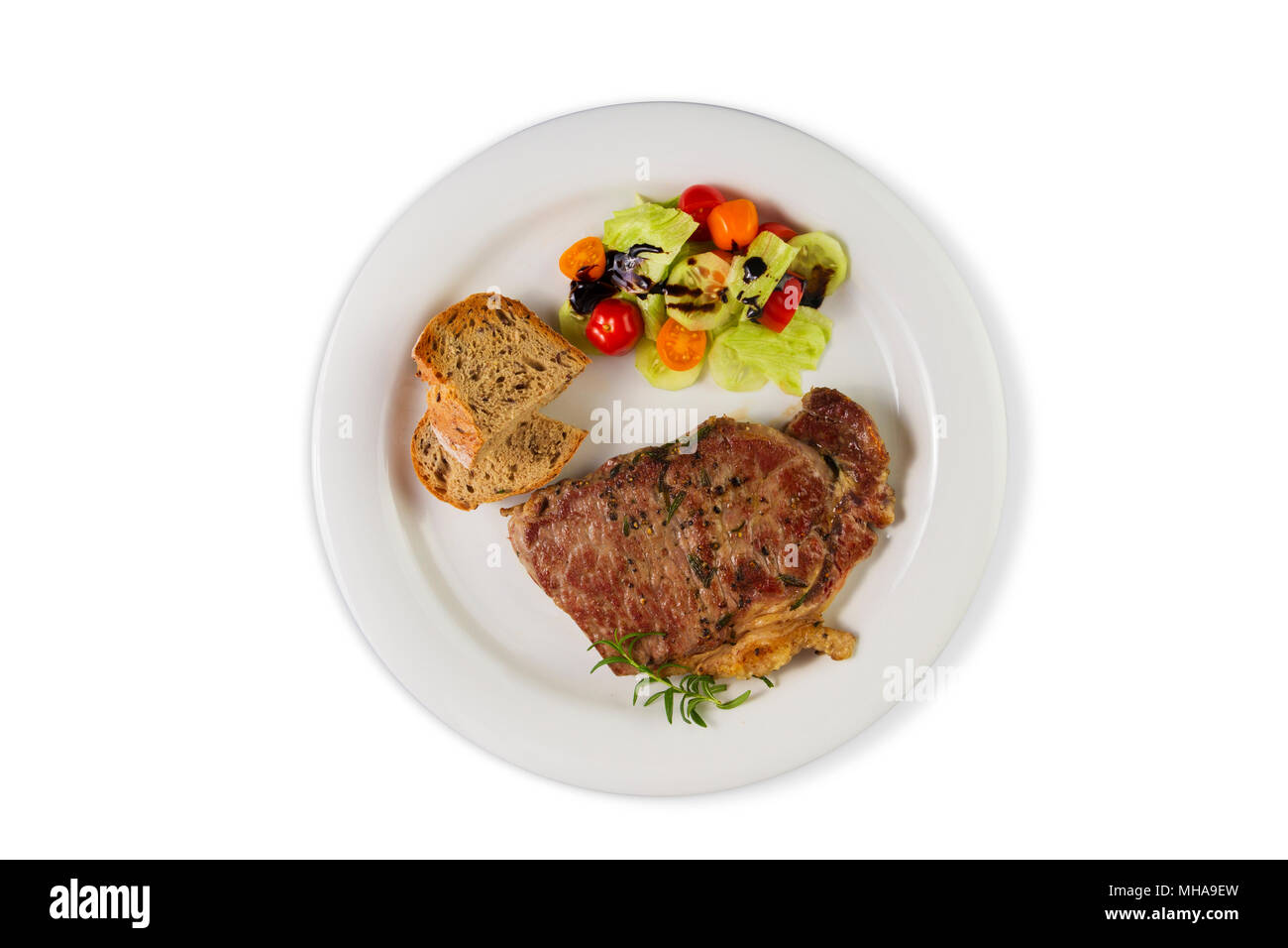 Reife, erfahrene Rind Rumpsteak oder Roastbeef Steak auf dem weißen Teller mit Salat und hausgemachtes Brot. Ansicht von oben auf weißem Hintergrund. Stockfoto