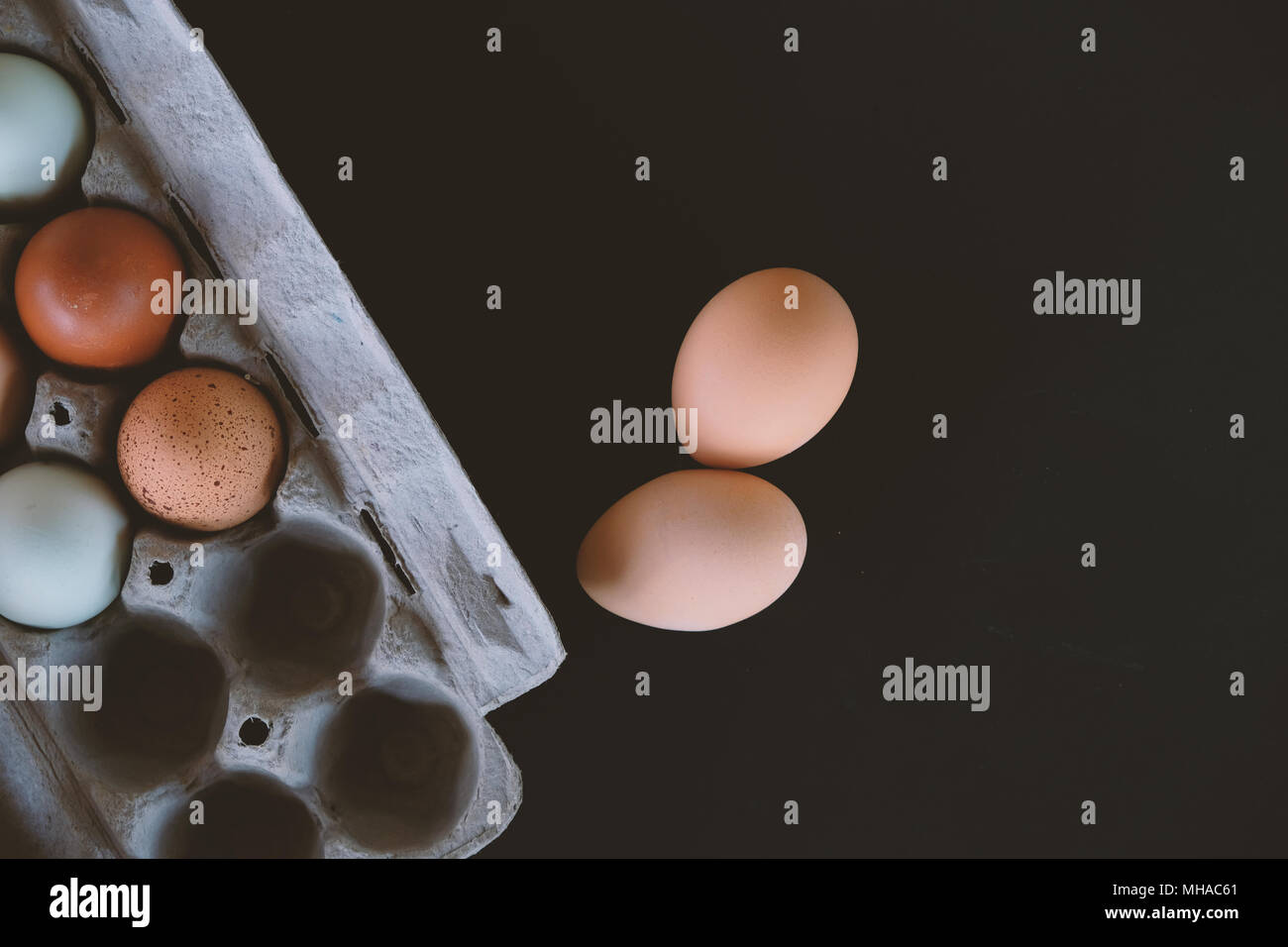 Bauernhof frisches Huhn Eier als Sammlung von Farben in Karton, Studio shot vor schwarzem Hintergrund. Stockfoto