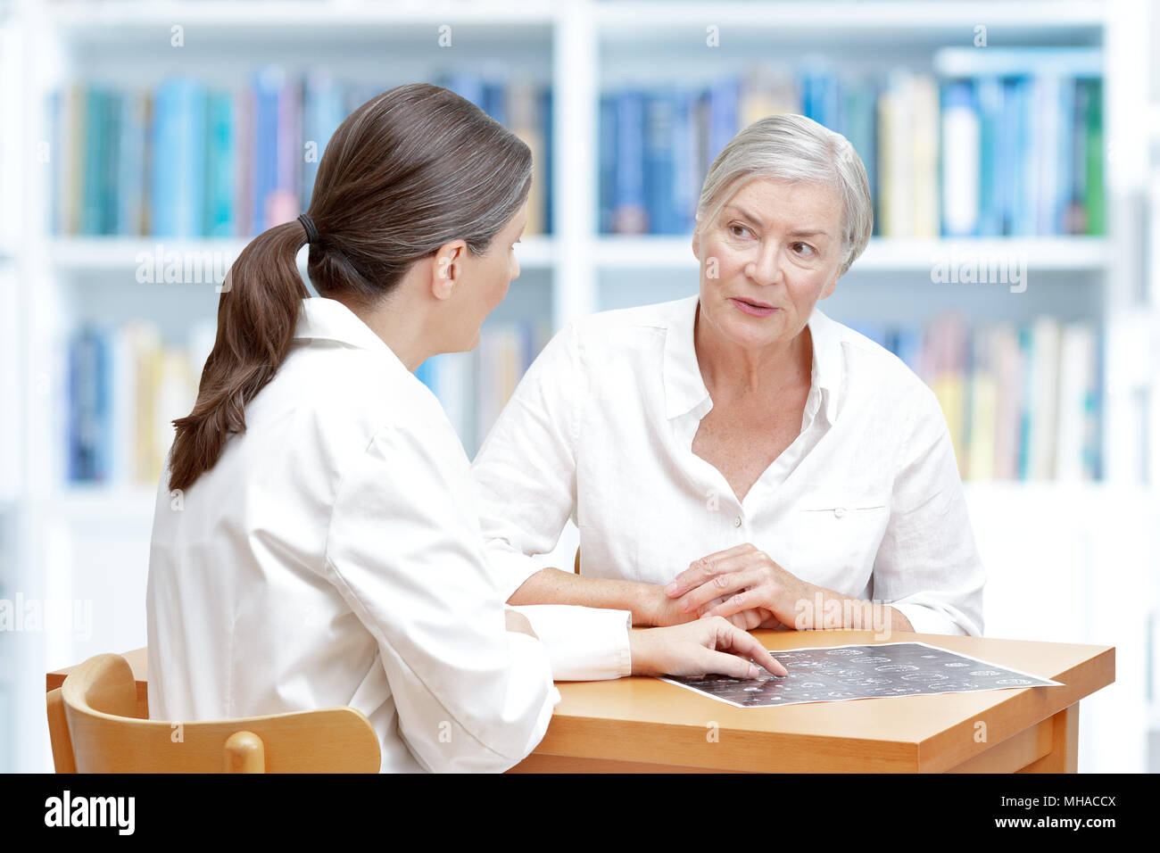 Frauen im mittleren Alter Arzt in ihre Chirurgie zeigt Ihr älterer Schlaganfallpatienten die neuesten CT Scan Ihres Gehirns Stockfoto